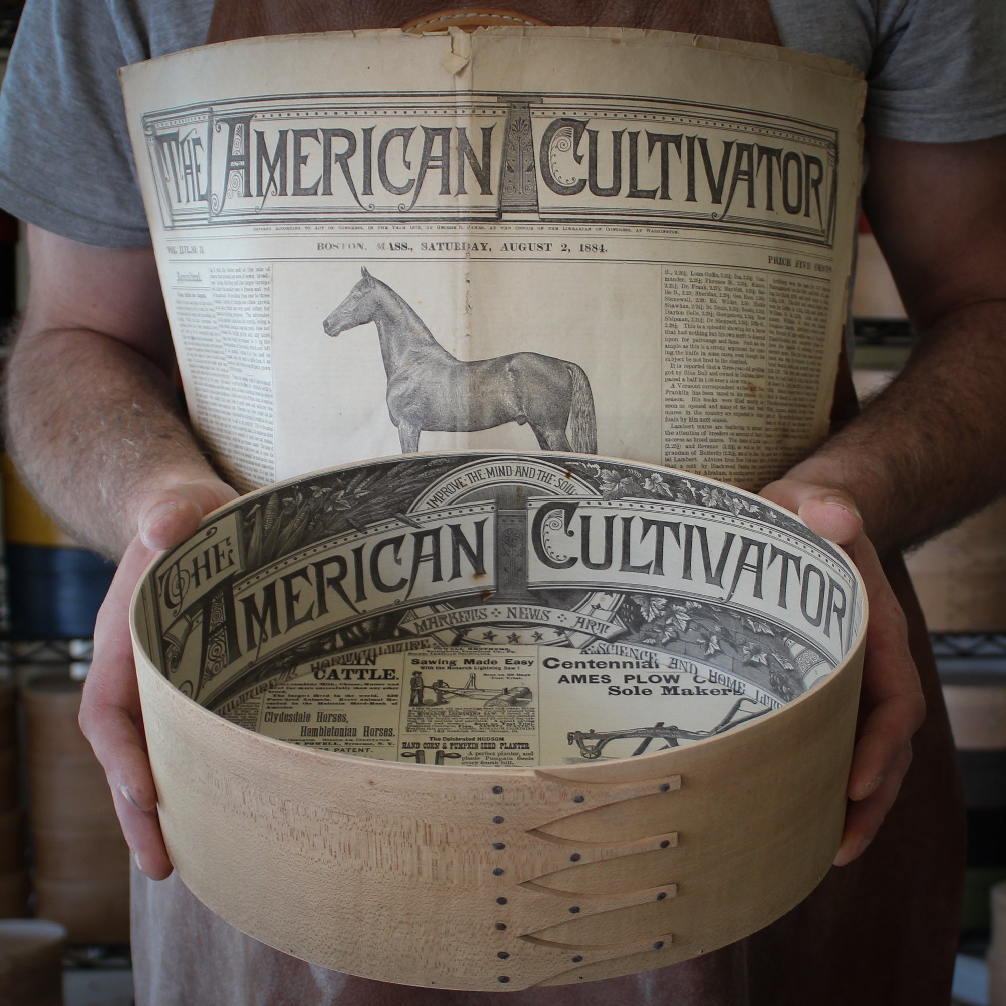 A shaker oval box lined with antique newspaper