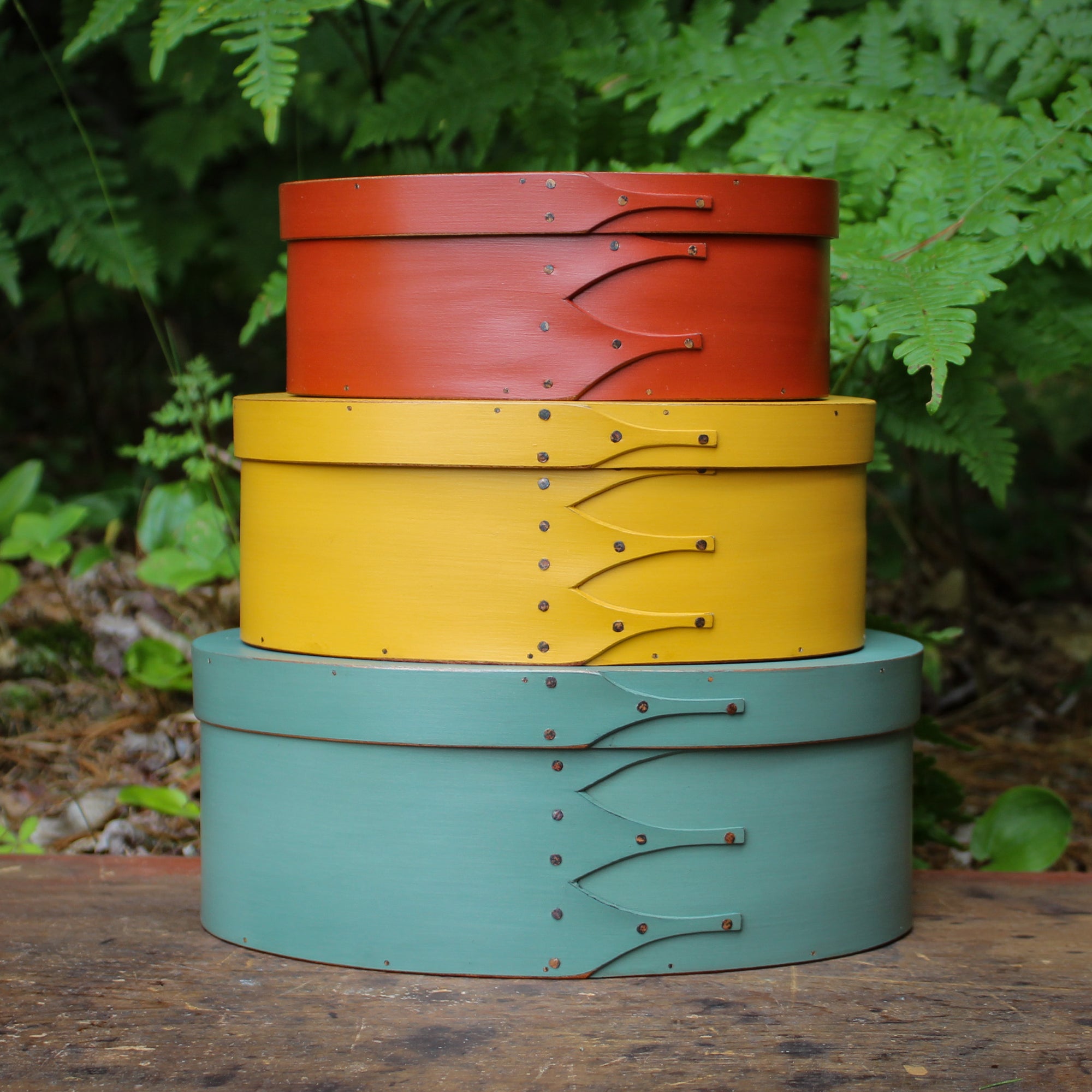 Stack of handcrafted Shaker oval boxes in various sizes and colors